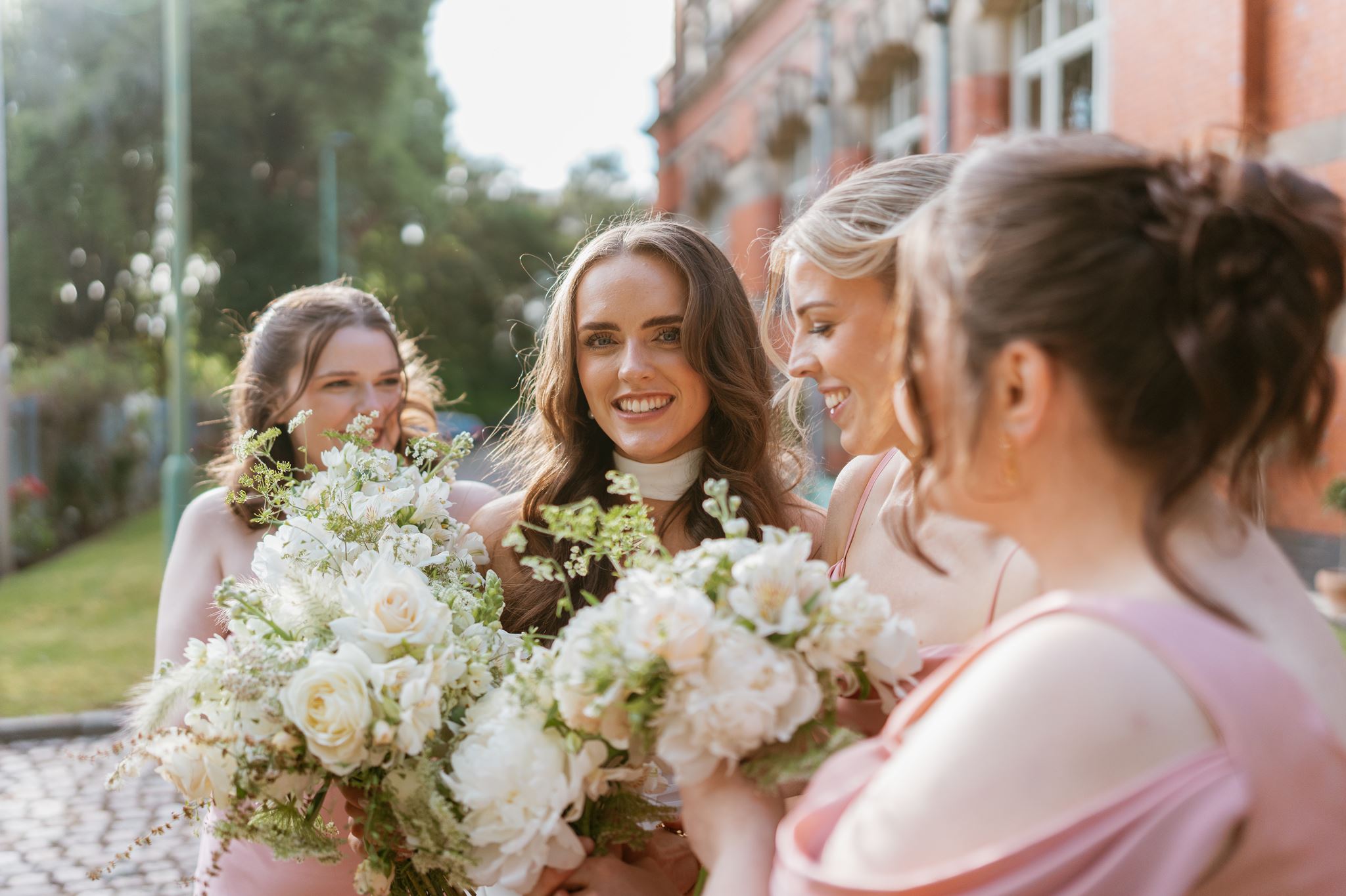 Bridesmaids laughing together with their bouquets